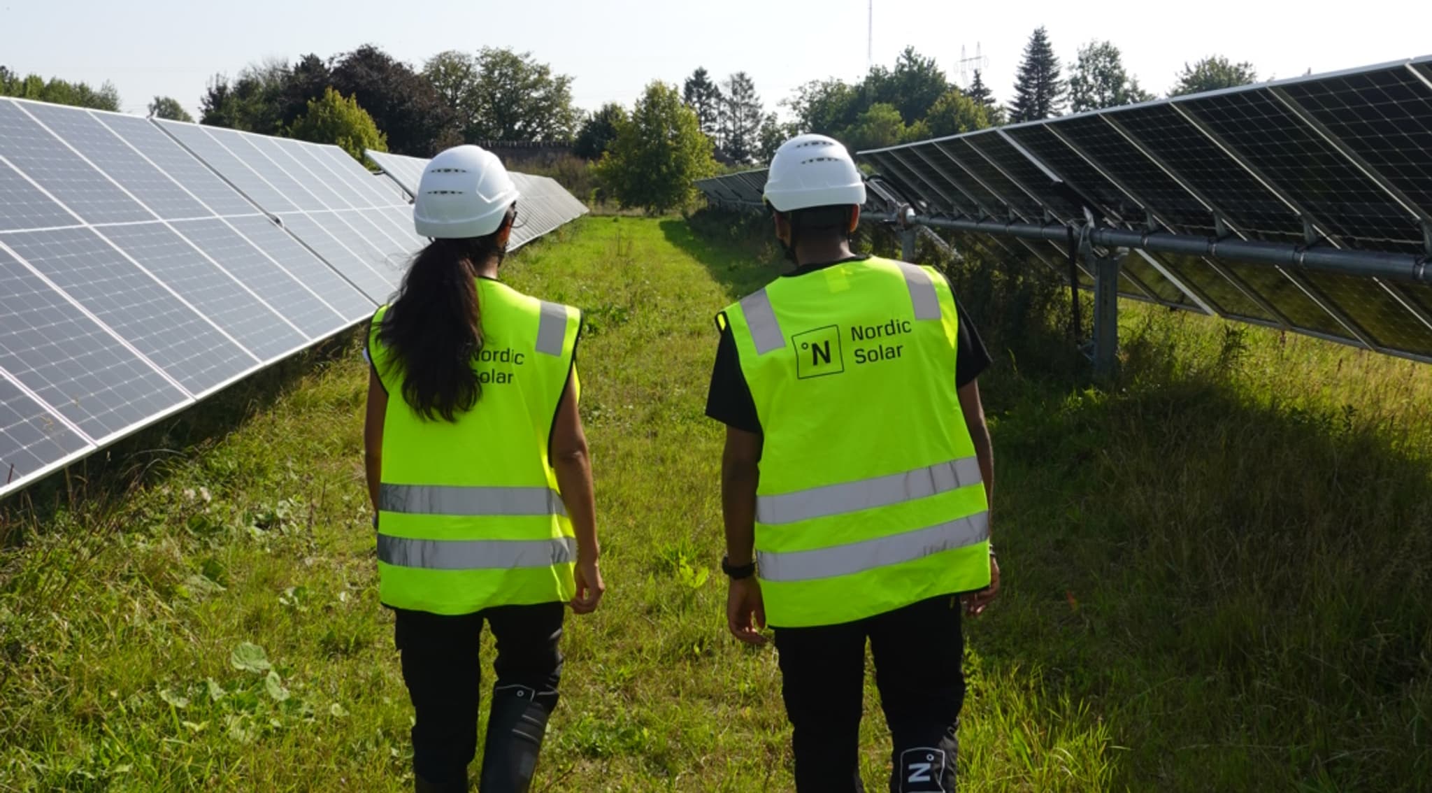 Two people walking at a solar park