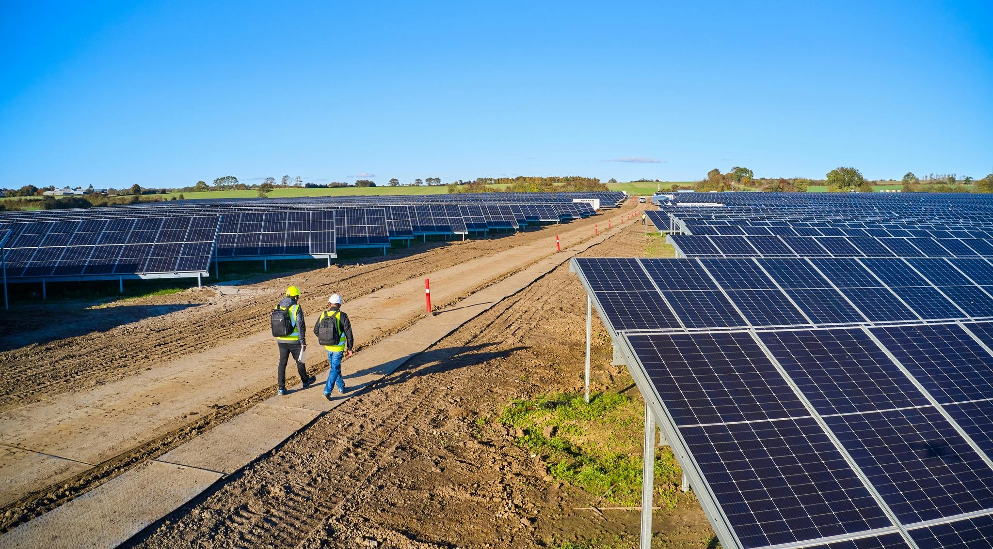 Two people walking at a solar park